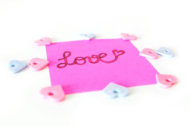 Pembe kağıt sopa not büyük bir beyaz arka plan üzerinde herhangi bir kullanım için yazılmış aşk metni ile.