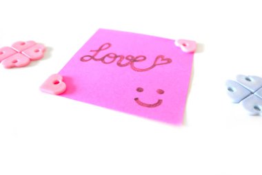 Pembe etiket kağıt kayda göre herhangi bir kullanım için büyük bir beyaz arka plan üzerinde aşk sözle çizilmiş gülümsemek yüz.