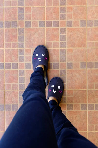 Female Legs in Blue Slippers. Woman in Smile Face Slippers Idea Concept on Tile Background Great for Any Use.