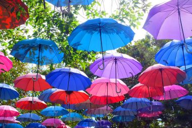 Gökyüzü bulutlar üzerinde herhangi bir kullanım için sokak arka plan büyük güzel renkli şemsiyeler.