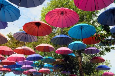 Gökyüzü bulutlar üzerinde herhangi bir kullanım için sokak arka plan büyük güzel renkli şemsiyeler.