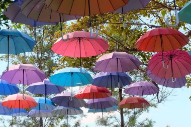 Gökyüzü bulutlar üzerinde herhangi bir kullanım için sokak arka plan büyük güzel renkli şemsiyeler.