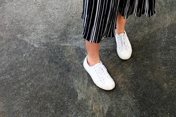 白色运动鞋 女人是腿在白色运动鞋和裤子在混凝土街道背景伟大的任何用途 — 图库照片