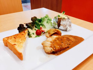 Izgara tavuk biftek ve beyaz tabak arka plan büyük herhangi bir kullanım için üzerinde fırında patates ile sebze salatası.