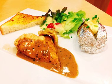 Izgara tavuk biftek ve beyaz tabak arka plan büyük herhangi bir kullanım için üzerinde fırında patates ile sebze salatası.