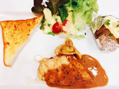 Izgara tavuk biftek ve beyaz tabak arka plan büyük herhangi bir kullanım için üzerinde fırında patates ile sebze salatası.