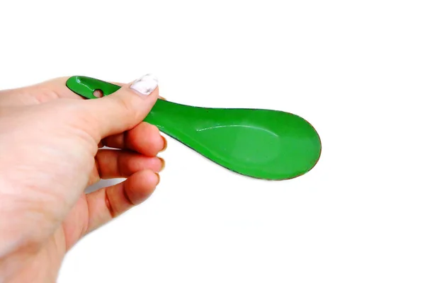 女人手里拿着一把勺子修剪过的花岗岩钉子 在白色背景上关闭绿色锌勺 — 图库照片