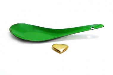 Altın kalp sevgi kavramı. Sevgililer günü beyaz zemin üzerine yeşil çinko kaşık ile altın kalp şekilleri