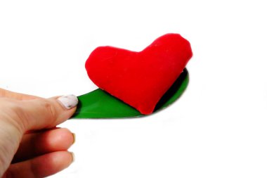 Bir kaşık ve kırmızı kalp Holding ile kadın eli. Sevgililer yeşil çinko kaşık ve beyaz arka plan büyük üstünde herhangi bir kullanım için izole kalp sevgi kavramı.