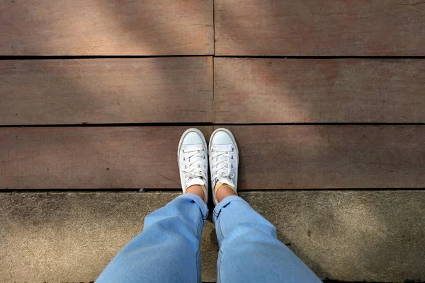 Fashion Female White Sneaker Blue Jeans Wooden Floor Background Great — стоковое фото