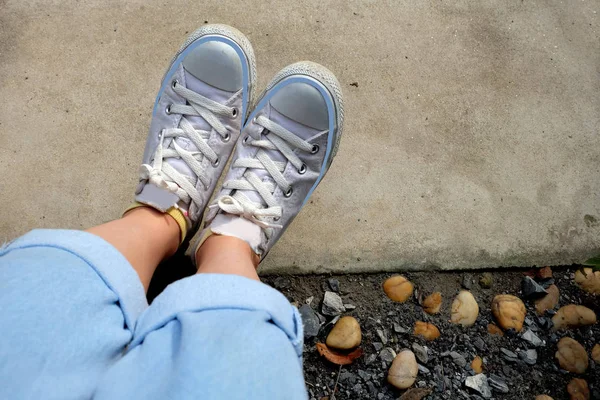 Mode Weiblich Weißen Turnschuhen Mit Blauen Jeans Auf Dem Zementboden — Stockfoto