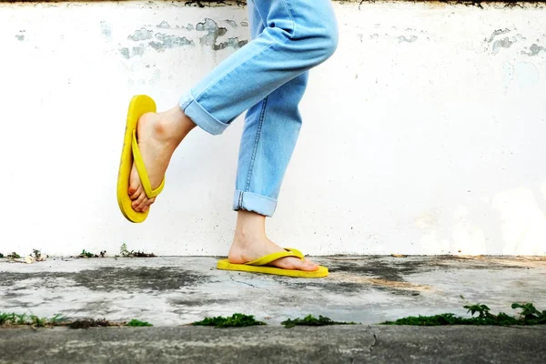Sandálias Amarelas Mulher Vestindo Chinelos Calças Brim Azuis Fundo Piso — Fotografia de Stock