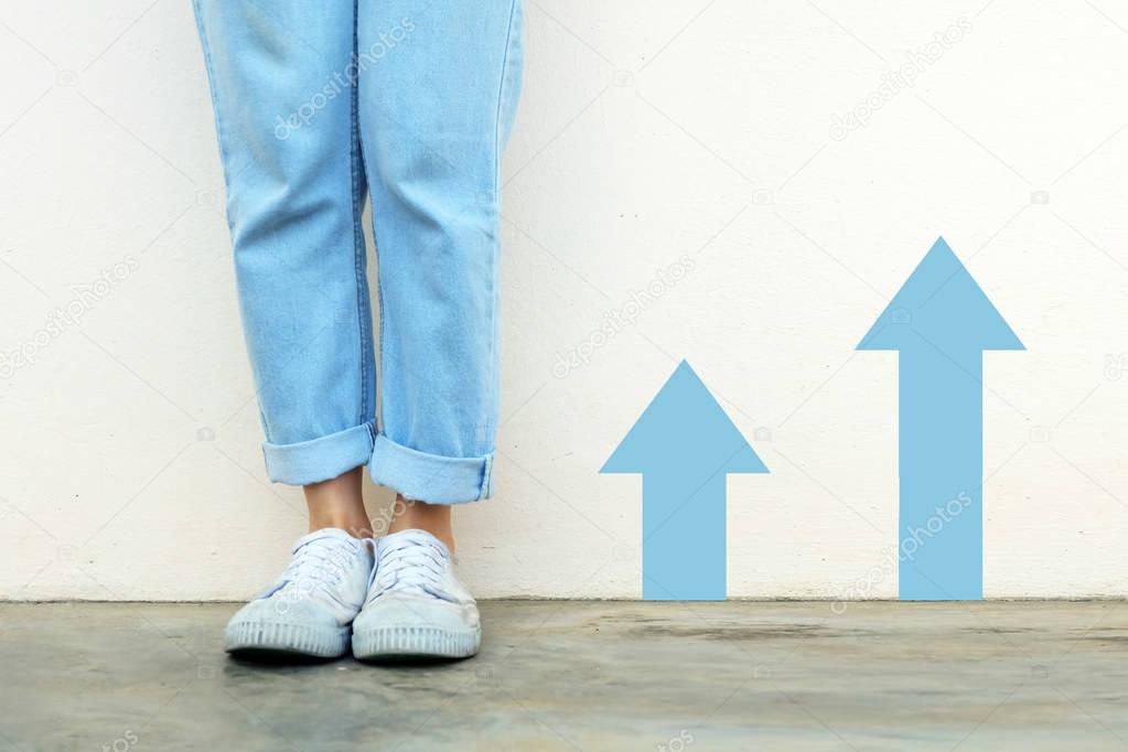 White Shoes Concept. Female Wearing White Sneakers with Blue Arrows Line Direction on Concrete Road Background Great for Any Use.