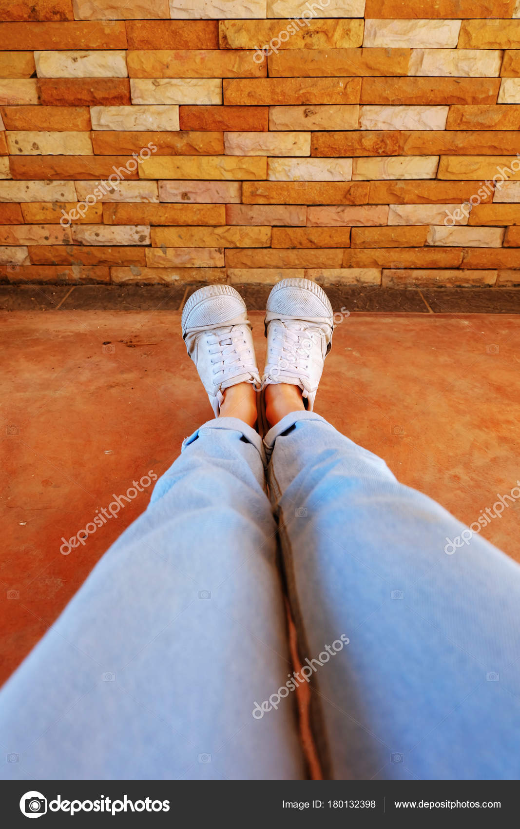 Old White Shoes. Woman Wear White Sneaker And Blue Jeans On Orange