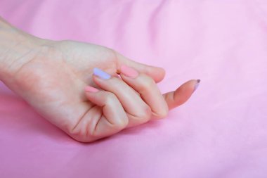 Güzel pembe tırnak cilası. Herhangi bir kullanım için pembe kumaş arka plan büyük üzerinde pembe tırnak manikür ile eller.