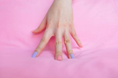 Güzel pembe tırnak cilası. Herhangi bir kullanım için pembe kumaş arka plan büyük üzerinde pembe tırnak manikür ile eller.