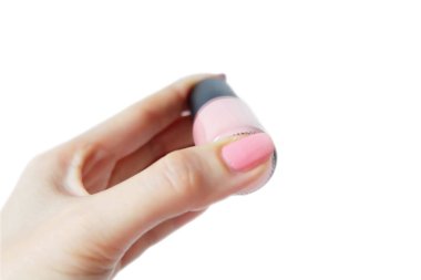 Elleri pembe boyalı çivi ile kapatın. Kadın pembe şişeyle güzel pembe tırnak manikür üzerinde beyaz arka plan büyük herhangi bir kullanım için eldir.