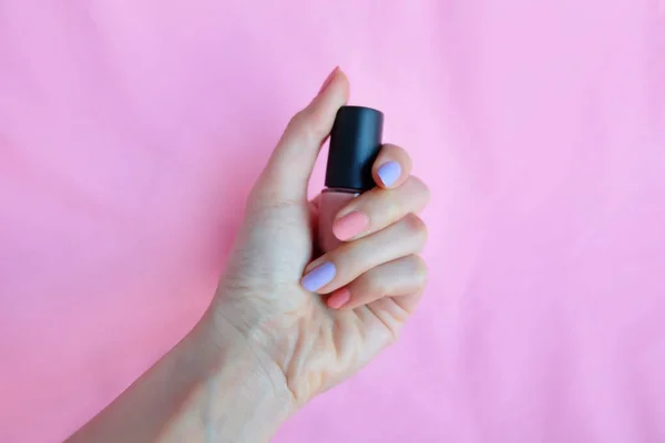Pink Painted Nails. Beautiful Pink Nail Manicure with Pink Bottle in Woman is Hand on Pink Background Great for Any Use.