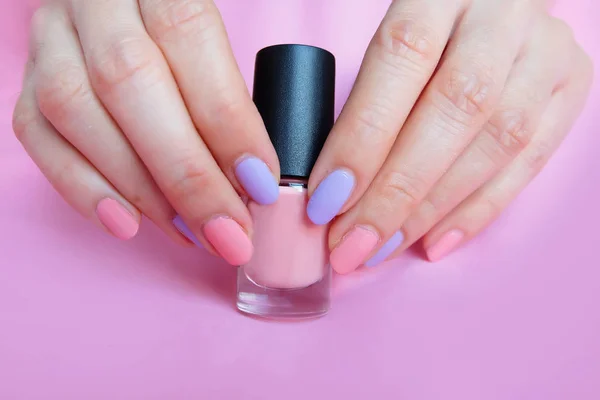 粉红色的指甲 美丽的粉红色的指甲指甲粉红色的瓶子在女人是手在粉红色的背景伟大的任何使用 — 图库照片