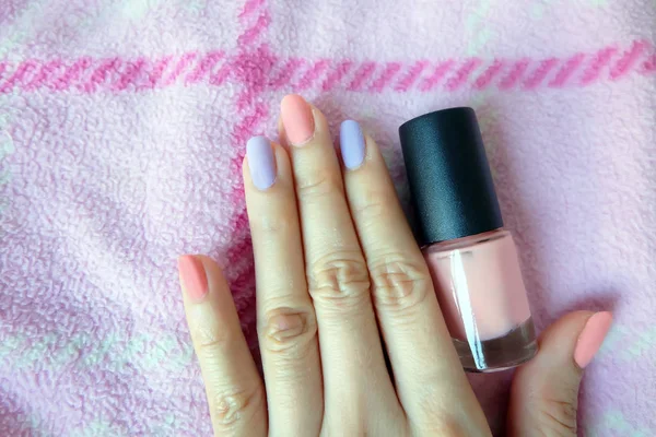 Pink Painted Nails. Beautiful Pink Nail Manicure with Pink Bottle in Woman is Hand on Pink Background Great for Any Use.