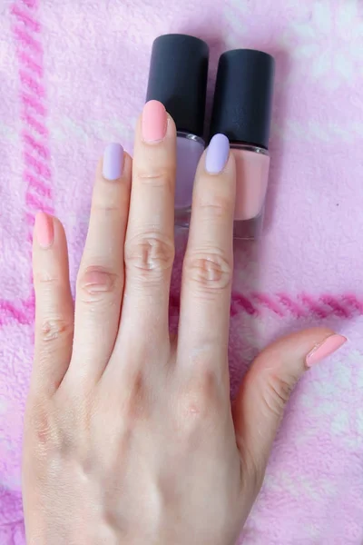 ピンク塗られた爪 女性のピンクのボトルと美しいピンクの爪マニキュアは任意の使用のために大きいピンク背景に手 — ストック写真