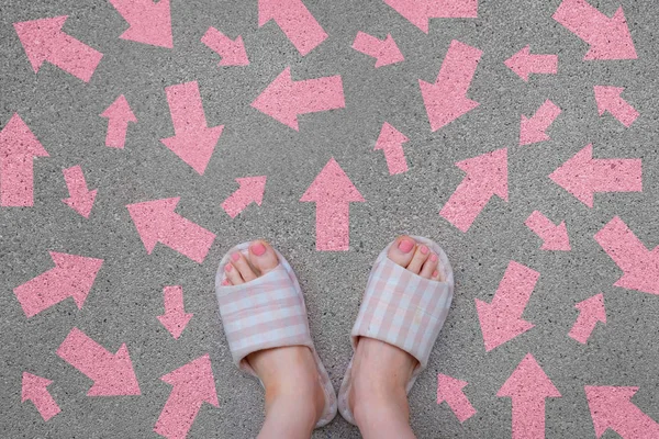 Damalı sıcak terlik. Kadın ayakta pembe Pembe okları yönü olan çimento arka plan büyük üstünde için herhangi bir kullanım ayakkabıları.