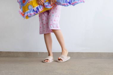 Damalı sıcak terlik. Kadın pembe pijama pantolon ve pembe yastık kat arka plan büyük üstünde tutan herhangi bir kullanım için ayakkabı.