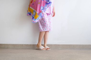 Damalı sıcak terlik. Kadın pembe pijama pantolon ve pembe yastık kat arka plan büyük üstünde tutan herhangi bir kullanım için ayakkabı.