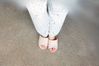 Damalı terlik üstten görünüm çifti. Kadın bacakları pijama ve çimento arka plan büyük için herhangi bir kullanım üzerinde pembe terlik (ayakkabı).