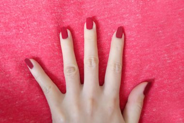 Güzel kadın kırmızı tırnak. El ile kırmızı kumaş arka plan büyük üstünde herhangi bir kullanım için izole kırmızı tırnaklar manikür.