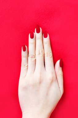 Güzel kadın kırmızı tırnak. El ile kırmızı kumaş arka plan büyük üstünde herhangi bir kullanım için izole kırmızı tırnaklar manikür.