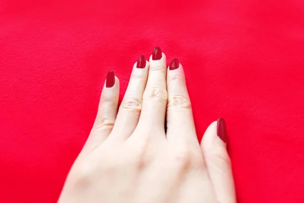 Beautiful Woman Red Nail. Female Hand with Red Nails Manicure Isolated on the Red Fabric Background Great for Any Use.