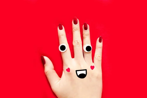 バレンタインの赤い爪のマニキュア 笑顔と赤い布の背景の偉大な任意の使用のため分離された赤色の爪と手を変な顔 — ストック写真
