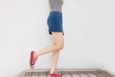 Boş alan kırmızı spor ayakkabılar. Güzel ince kadın bacakları kırmızı ayakkabılar ve Jean etek kat arka plan büyük herhangi bir kullanım için üzerinde.