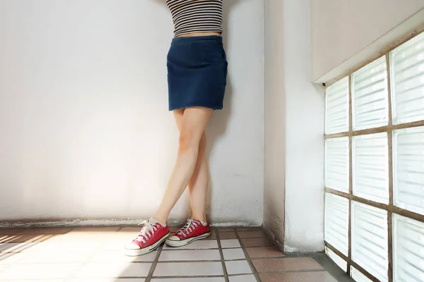 空き領域の赤いスニーカー スリム美人足の赤い靴と床背景偉大な任意の使用のためのジーンのスカート — ストック写真