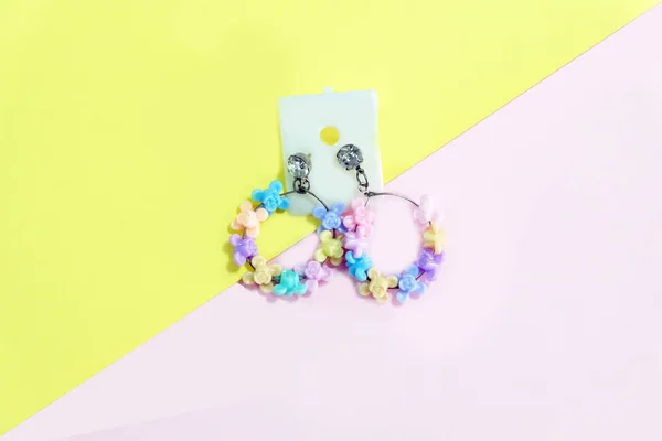 箍耳环时尚饰品 美丽的首饰耳环与五颜六色的花朵 粉红色和黄色粉彩背景伟大的任何使用 — 图库照片