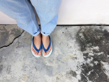 Mavi Flip Flop izole çimento zemin, üstten görünüm. Beton arka plan büyük üstünde herhangi bir kullanım için mavi ayakkabı ve Aksesuar kot giyen güzel kadın.