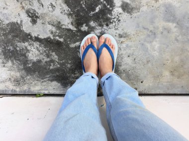 Mavi Flip Flop izole çimento zemin, üstten görünüm. Beton arka plan büyük üstünde herhangi bir kullanım için mavi ayakkabı ve Aksesuar kot giyen güzel kadın.