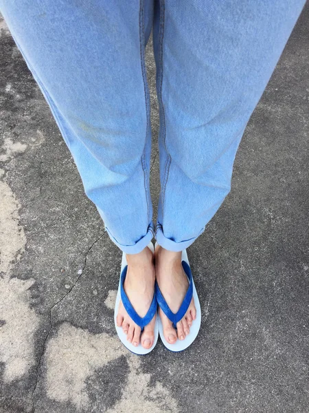 Mavi Flip Flop izole çimento zemin, üstten görünüm. Beton arka plan büyük üstünde herhangi bir kullanım için mavi ayakkabı ve Aksesuar kot giyen güzel kadın.