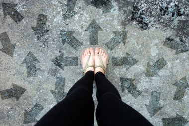 Çok yön ok seçenek. Altın Ayakkabı beton zemin üzerinde üstten görünüm izole. Ayak giyen Flip Flop (Peep) çimento zemin arka plan büyük için herhangi bir kullanım üzerinde duran kadın olduğunu.