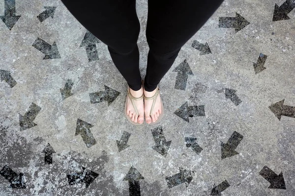 Many Direction Arrow Choices. Gold Shoes Isolated on Concrete Floor,Top View. Woman Standing is Feet Wearing Flip Flop (Sandal) on The Cement Floor Background Great For Any Use.