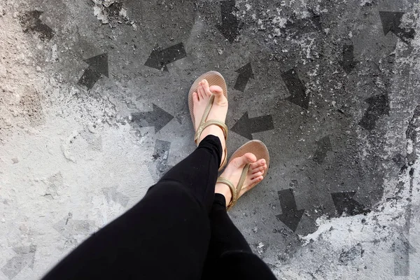 Many Direction Arrow Choices. Gold Shoes Isolated on Concrete Floor,Top View. Woman Standing is Feet Wearing Flip Flop (Sandal) on The Cement Floor Background Great For Any Use.