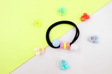 Boncuk moda aksesuarları ile siyah lastik bant. Saç elastik bant ile özgür yer. Siyah saç bandı ile pembe ve Sarı zemin üzerine izole renkli saç tokası