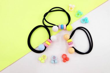 Boncuk moda aksesuarları ile siyah lastik bant. Saç elastik bant ile özgür yer. Siyah saç bandı ile pembe ve Sarı zemin üzerine izole renkli saç tokası