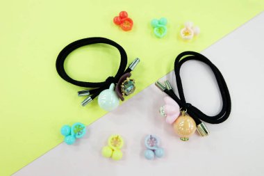 Boncuk moda aksesuarları ile siyah lastik bant. Saç elastik bant ile özgür yer. Siyah saç bandı ile pembe ve Sarı zemin üzerine izole renkli saç tokası