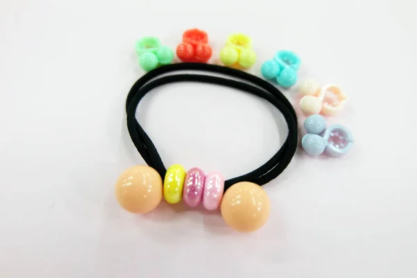 Black Rubber Band with Bead Fashion Accessories. Hair Elastic Band with Free Space. Black Hair Band with Colorful Hair Clip Isolated on Pink Background