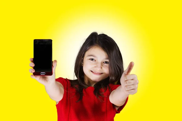 Улыбающаяся маленькая девочка с мобильным телефоном — стоковое фото