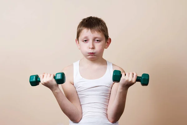 Tired,Bored,upset little boy with dumbbell.Facial expression,Sport