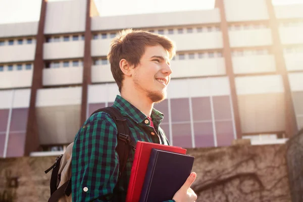 Człowiek młody student University.Smiling trzyma książkę i worek — Zdjęcie stockowe