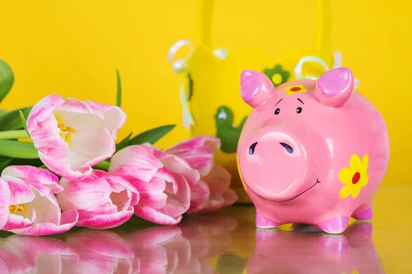 Hucha de monedas de cerdo sobre fondo amarillo con flores —  Fotos de Stock
